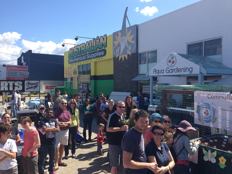 Visitors lining up to plant seedlings on the Community Aquaponic Garden opening day